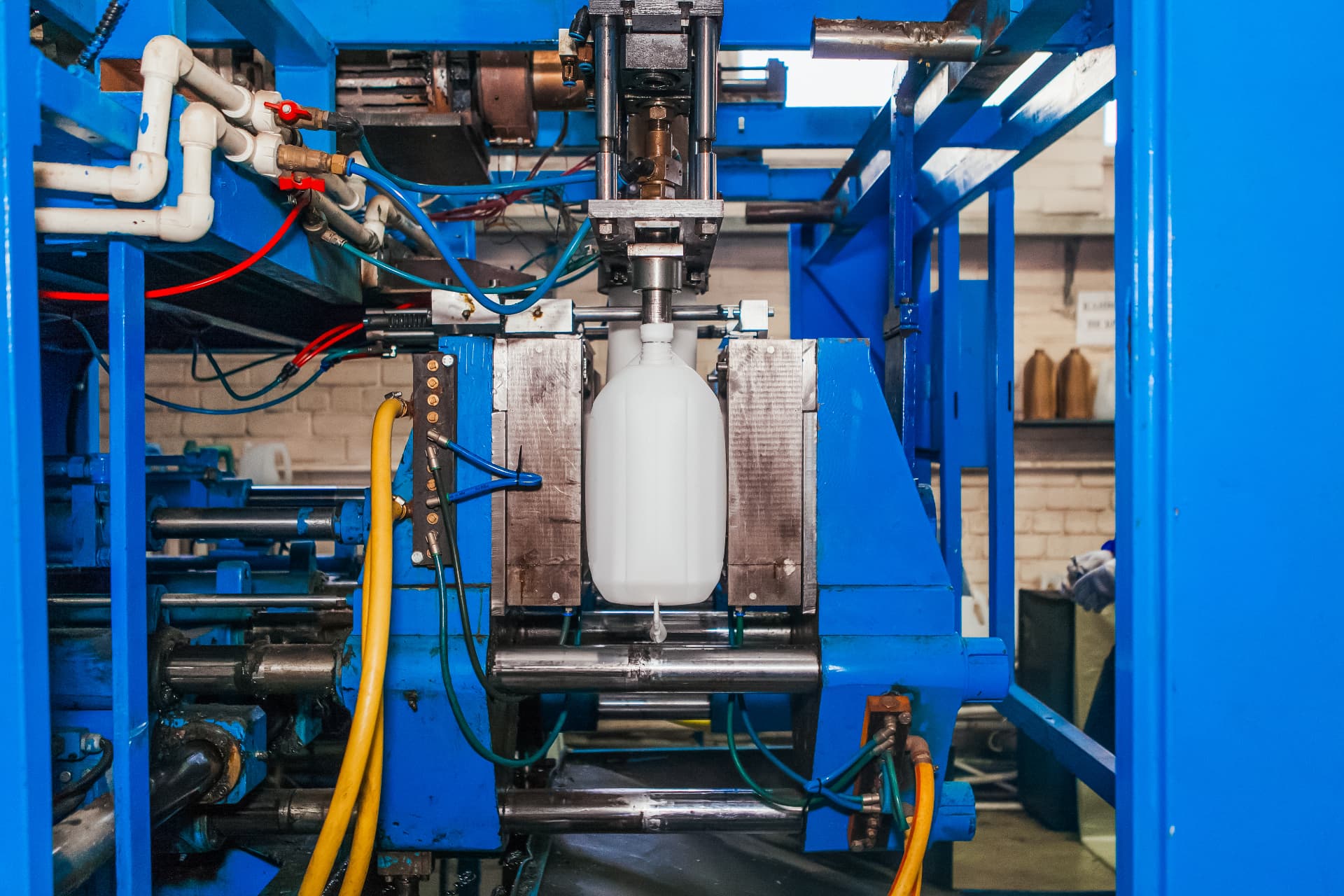 Extrusion blow moulding machine forming an HDPE bottle inside the mould